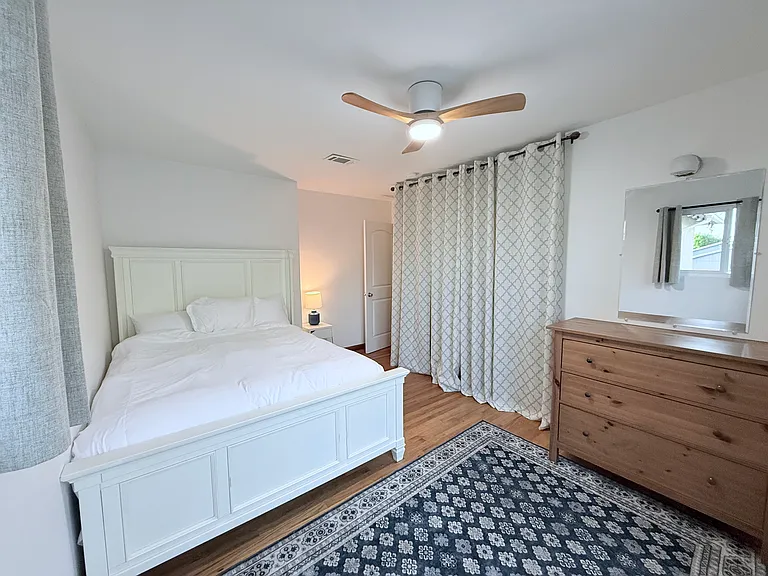Queen bedroom with sliding door with direct backyard access.