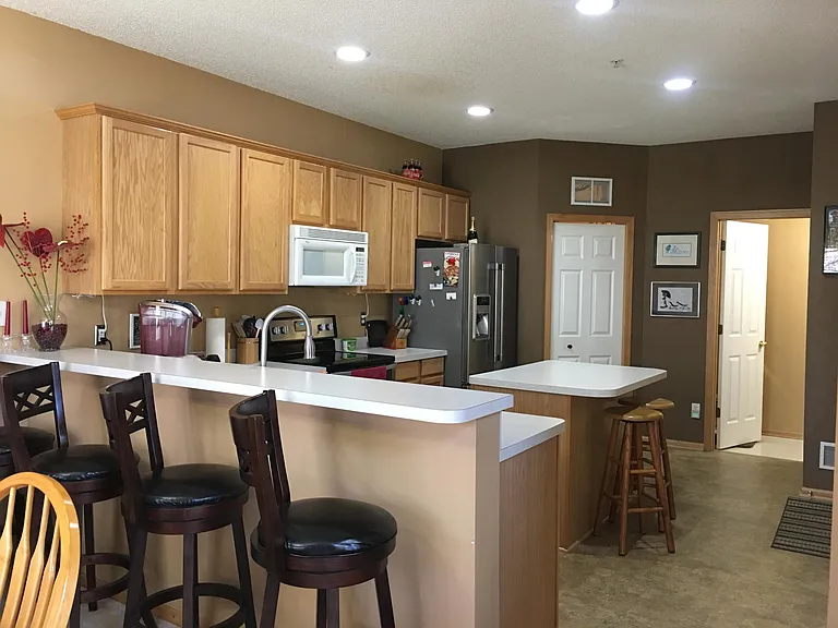Another view of the kitchen with breakfast bar and island.