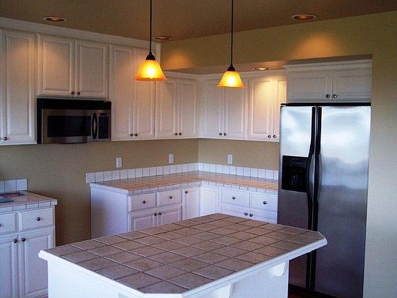 Open kitchen with tile counters and island.