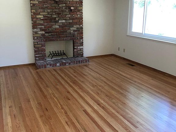 Living room, hardwood floors (newly refinished), front door entrance to the right of window.