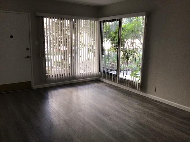 Living room, looking at front door and windows onto courtyard.