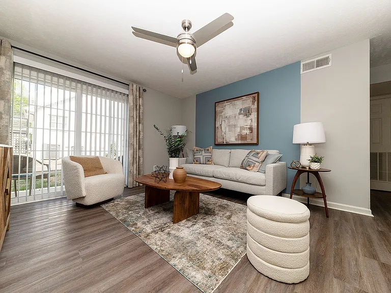 Spacious living room with hardwood-style flooring & ceiling fan