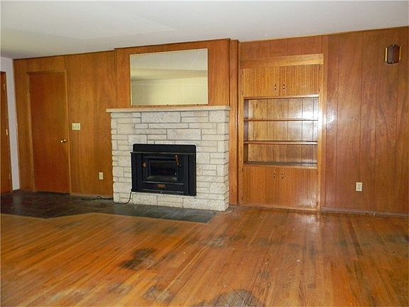 There are built in cabinets set in the living room wall.