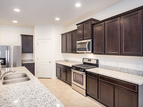 Designer kitchen with stainless steel appliances, granite countertops, and espresso cabinetry.