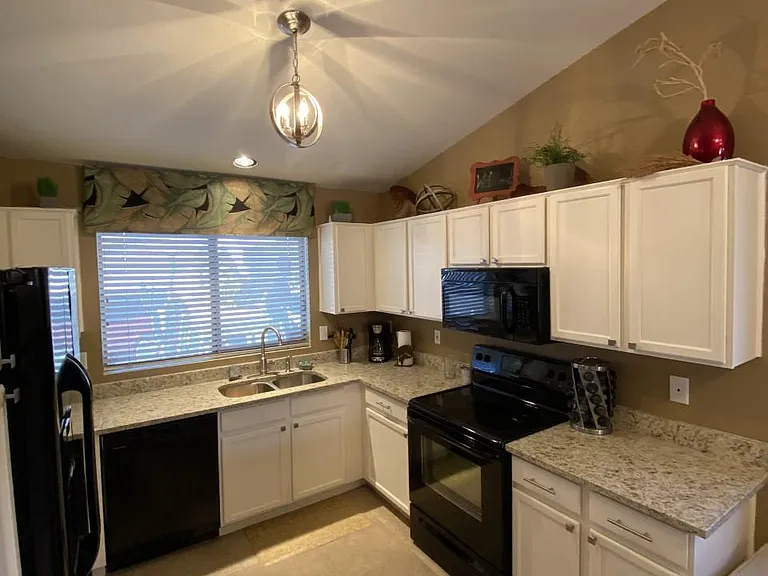 Completely updated kitchen with granite, refinished cabinetry, deep sinks, new tall faucet, new lighting and more!