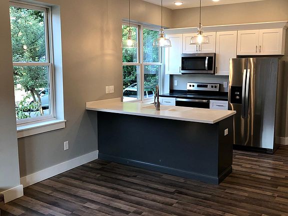 Bright kitchen with stainless steel appliances, solid surface counters and custom wood cabinets!