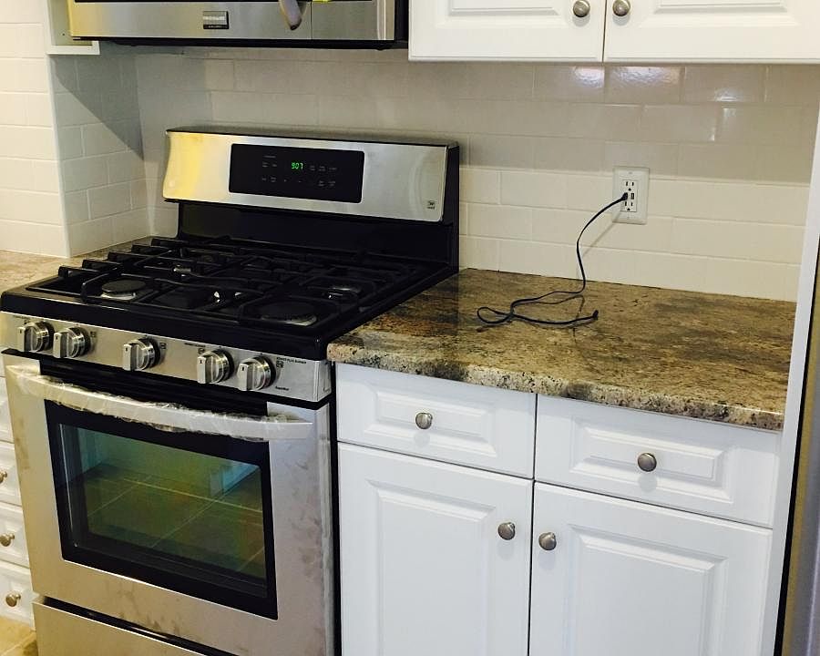 granite countertops, new stove, microwave, and fridge
