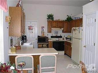 Kitchen features vaulted ceiling, plenty of cabinets, pantry