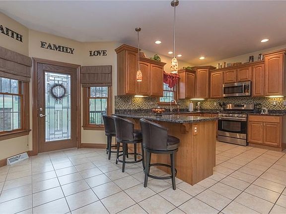 The 14X14 kitchen features a breakfast bar w/seating, granite counter tops, SS appliances, mosaic glass backsplash & ceramic til