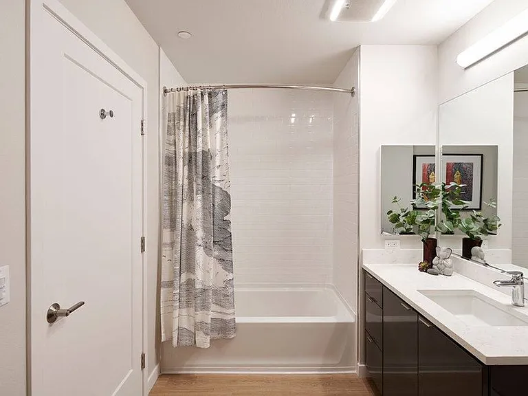 Floor-to-ceiling tile in showers and large frameless bathroom mirrors with built-in storage and shelving*