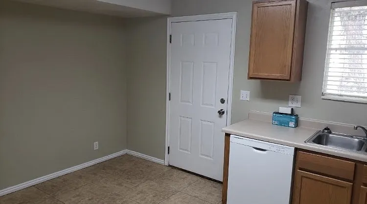 Large area for kitchen table and a back door that leads to the parking stall.