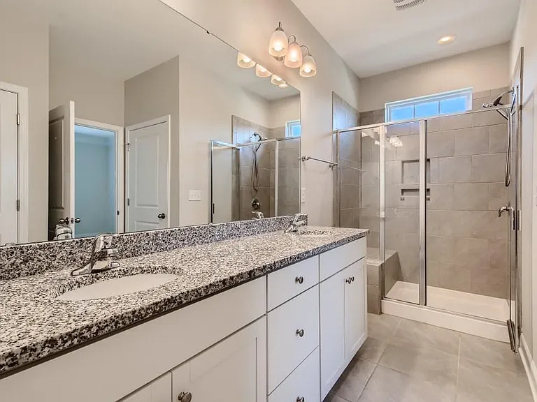 Primary Bathroom has dual vanity, large shower with bench and separate toilet room.