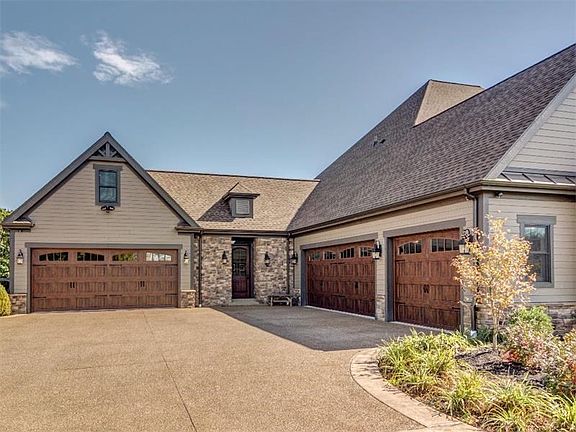 3 car garage side entry garage, and a 2 car garage is separated by a second covered entrance into a mudroom featuring 6 built in