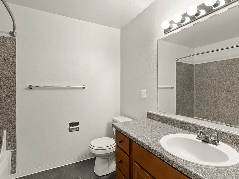 Bright bathroom with full vanity and tub.