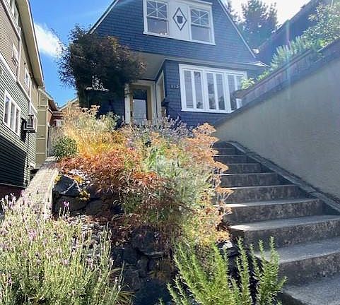Lovely landscaping greets you as you climb up to this home graciously set up off of the street