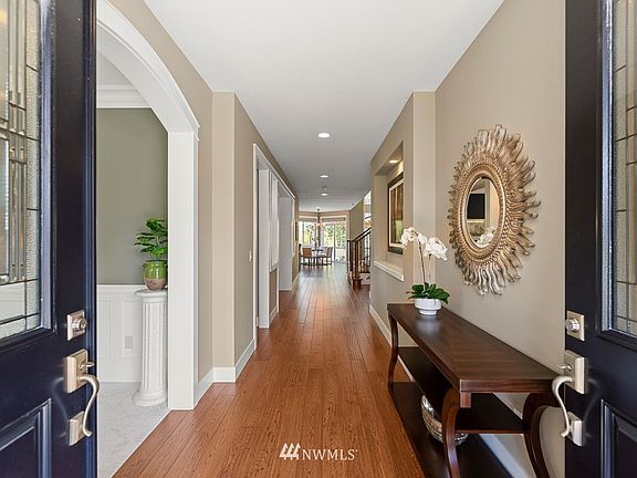 Double door entry welcomes you home. Wide-plank refinished floors at the entry flow through the hallway and into the kitchen and family room. To the left is the formal living room/den.