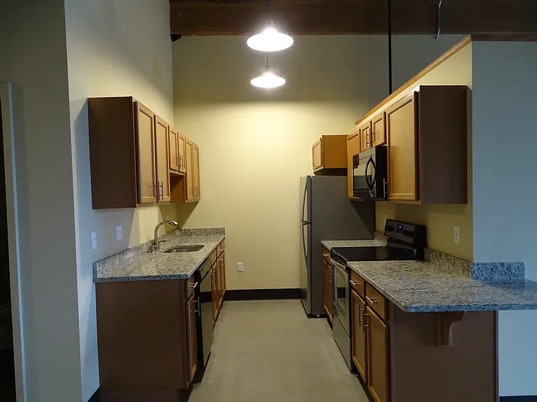 Apt 355 (2 BR) galley kitchen layout with chef's table into dining and living area.