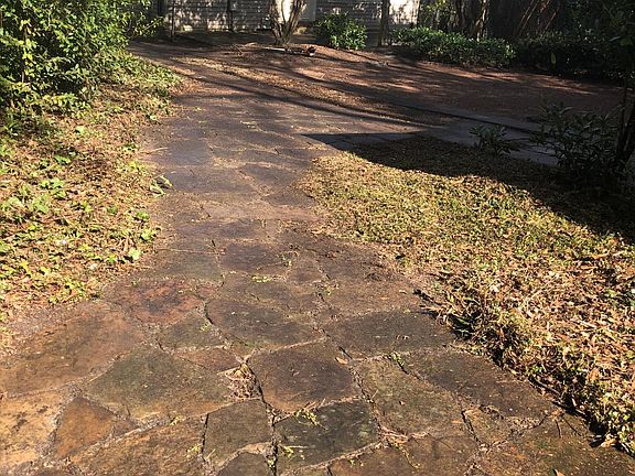 Stone walkway thru lovely landscaped fenced backyard.