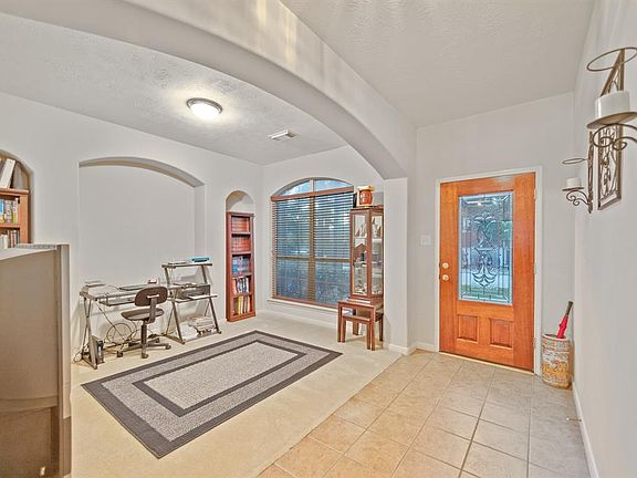 Beautiful 2" wood blinds, lead glass front door, arches and tile floor entry