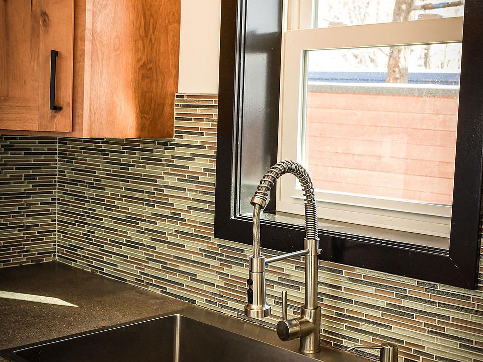 Very large kitchen sink with adjustable spray faucet, soap dispenser, and garbage disposal.