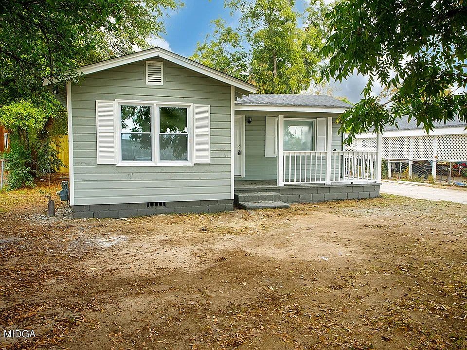 Well-maintained exterior featuring siding, large front windows for natural light, and a welcoming porch area.