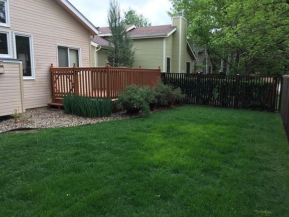 Rear deck overlooks low-maintenance fenced backyard