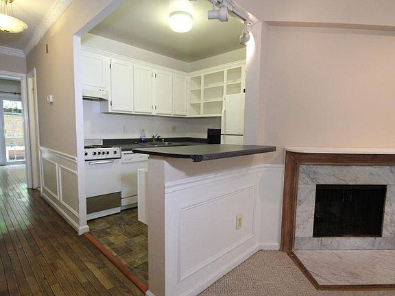 Hardwood floors, brightly lit kitchen and fireplace