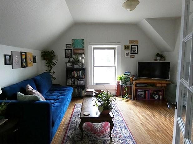 South facing living room with hardwood floors and angled ceiling.