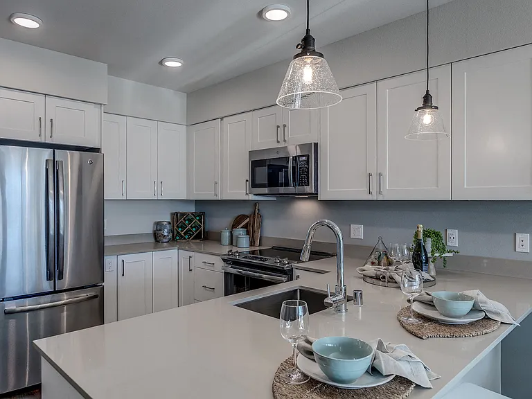 All Lux Apartments kitchens include stainless steel appliances including overhead venting microwave, dishwasher, double-door refrigerator with ice maker, and flat-top, electric stove and oven