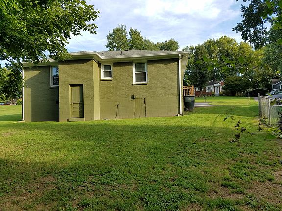Back view of home, note small storage room and tall crawl space entry door