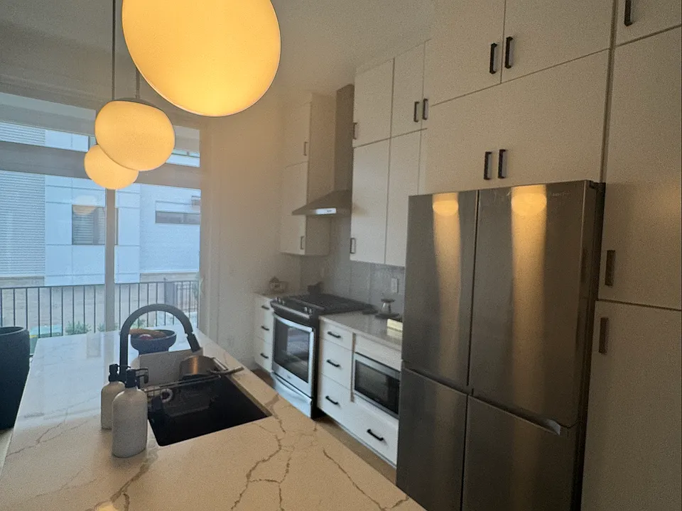 First Floor _ Kitchen with Waterfall Quartz Countertops and Four-Door Refrigerator with Beverage Center