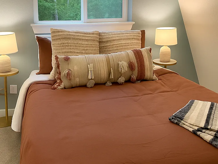 Charming upstairs bedroom with a cozy vibe and calming forest views