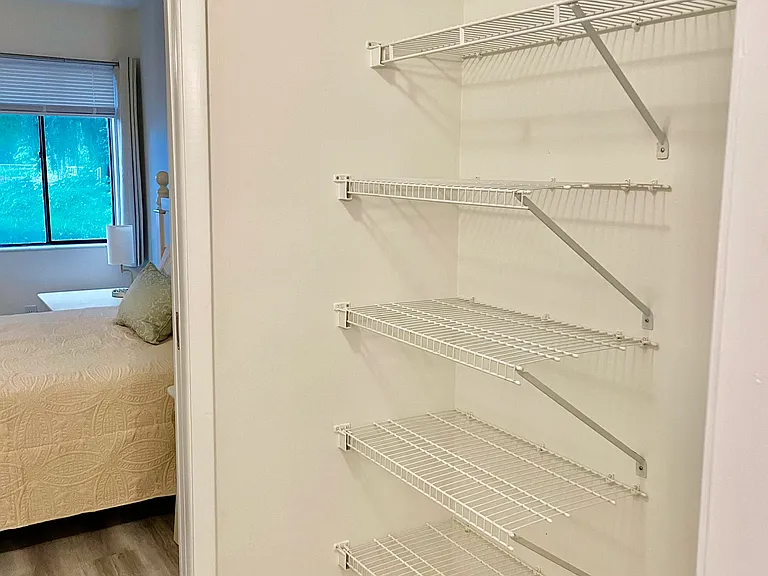 Walk through closet with plenty of storage and shelving