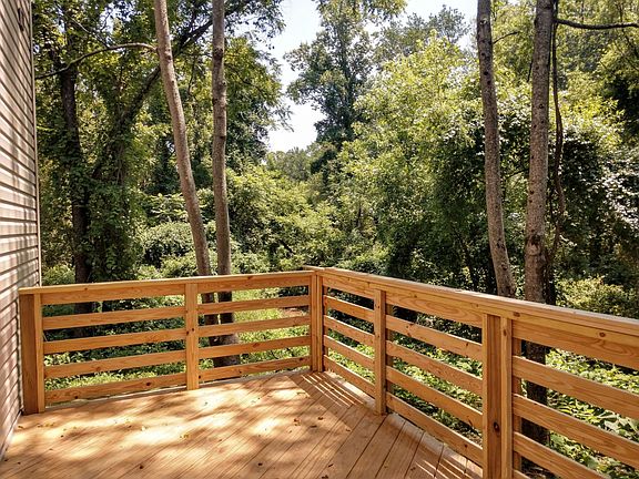 Back deck off kitchen, surrounded by woods and a creek.