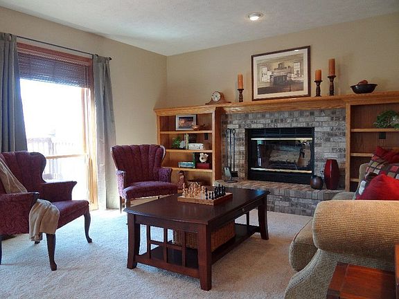 Living room has picture windows overlooking view & fireplace with builtins