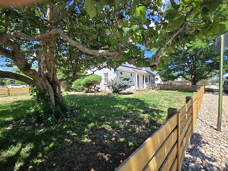 Large front yard with trees providing shade