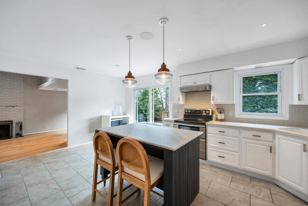  Spacious eat in kitchen with center island, stainless steel appliances.