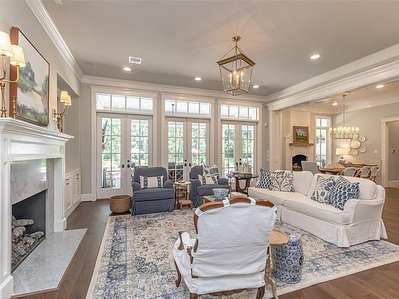 Family room with Wall of French doors for entertaining and accessing out door living area! Lots of natural lighting!R Real Wood floors throughout! Marble fireplace!