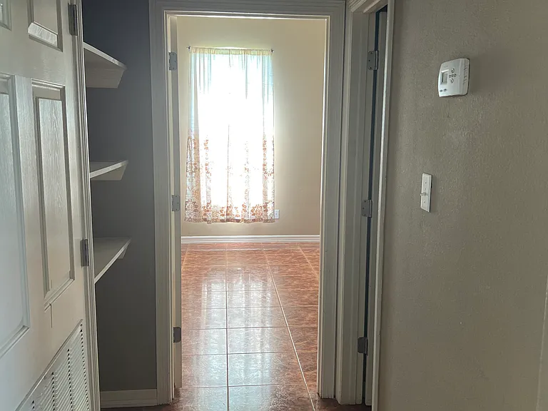 Private walkway leading into the master bedroom _ with convenient storage space on the left and a guest half-bath just to the right.