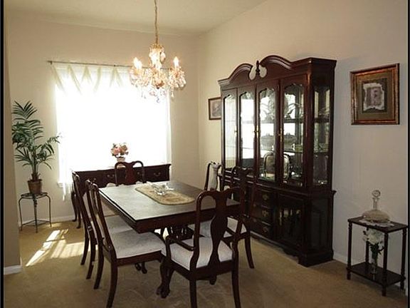 Formal dining room has chandelier.