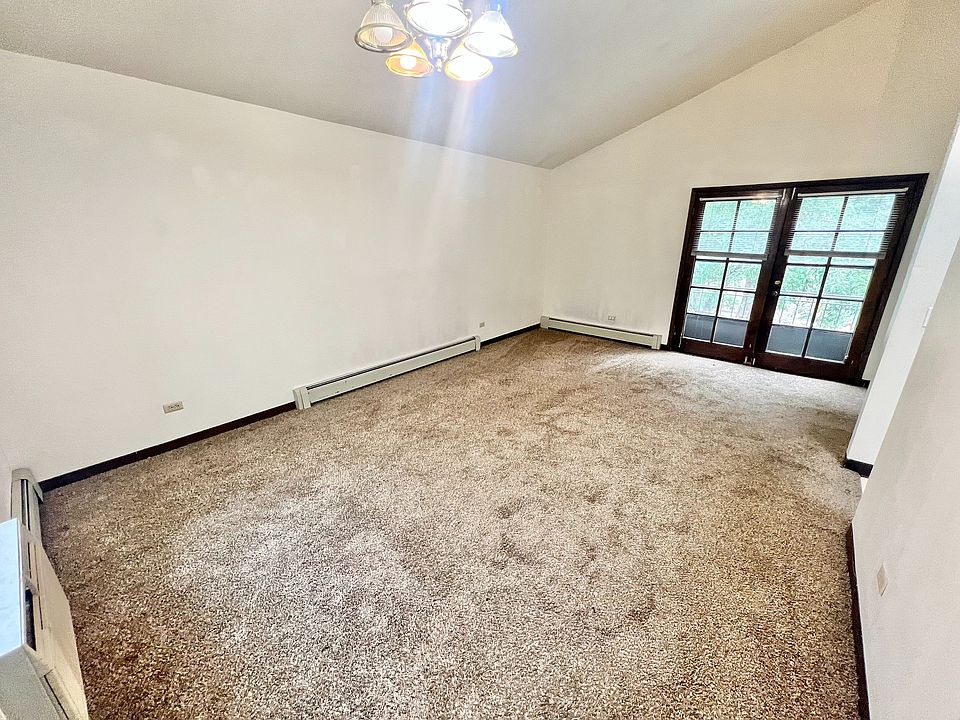 Bright living space with plush carpeting and elegant French doors, offering a cozy and inviting atmosphere.