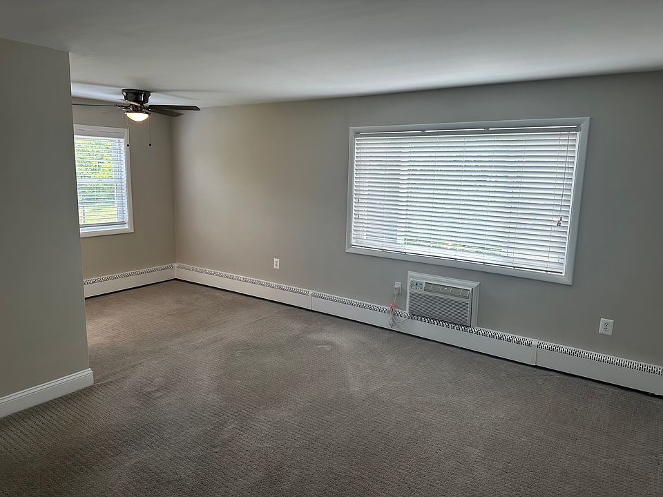 Living room with wall A/C and ceiling fan