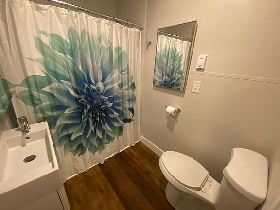 Single bathroom with shower/ tub. Large mirror with inside storage space. Radiant heating and fan.