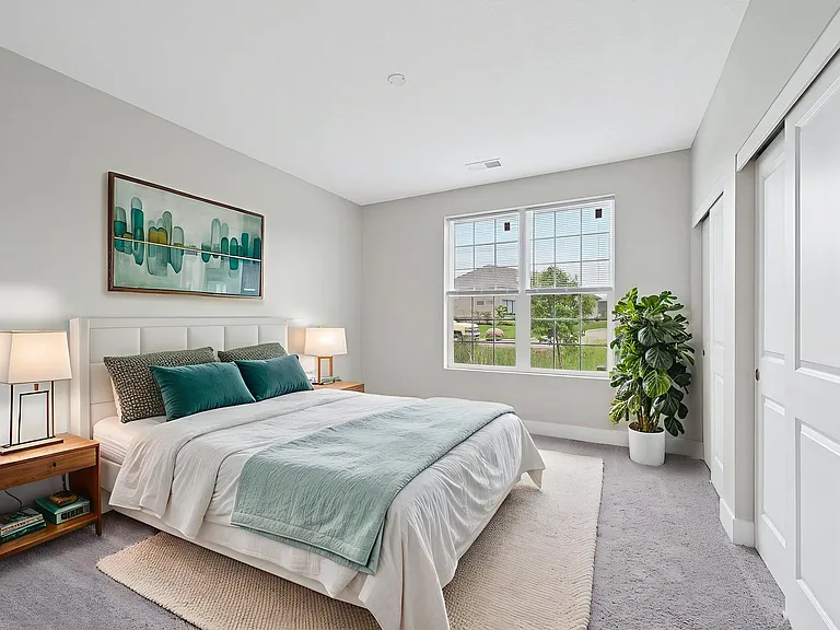 Dooley's Orchard apartment showing a bedroom layout with a large bed and a painting on the wall.