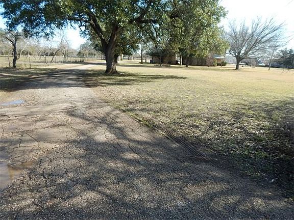 Driveway runs along the north boundary of the property to the main house