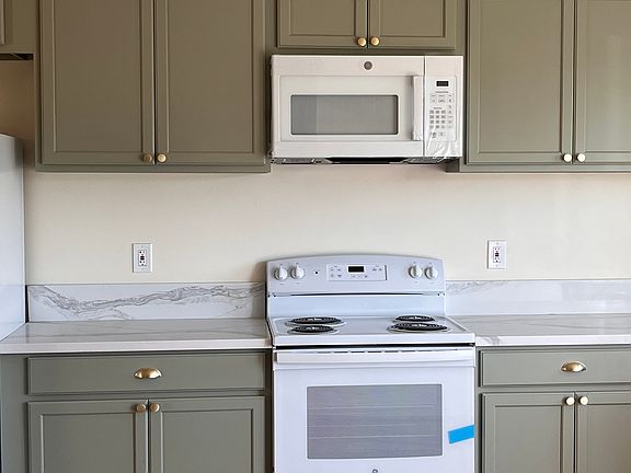 Kitchen with brand new, never used appliance and quartz countertops