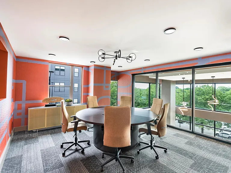 Vibrant conference space with floor-to-ceiling windows, perfect for meetings, brainstorming, or remote collaboration at Modera LoSo.