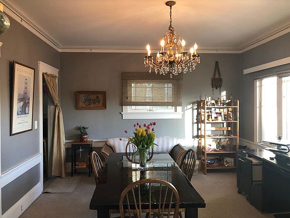 Spacious dining room with room for desk and dining table opens via archway to living room