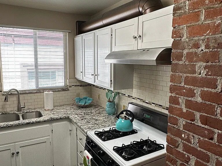 Exhaust flu above the cabinetry is a copper color. Antique bricks, give it that special vintage charm.