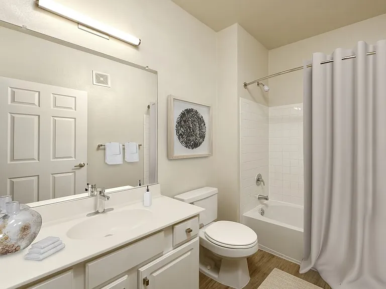 Renovated Package I bath with white countertops, white cabinetry, and hard surface flooring